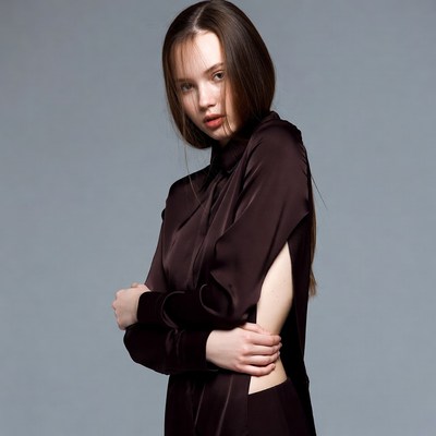 Woman in maroon silk shirt arms crossed