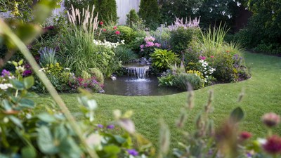 Garden pond with waterfall and flowers