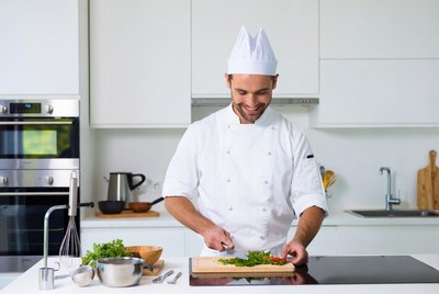 Chef chopping herbs on cutting board