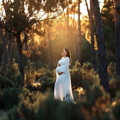 Pregnant woman in white dress forest
