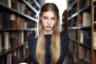 Blonde girl with bow in library