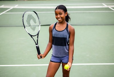 African-American girl holding tennis racket and ball