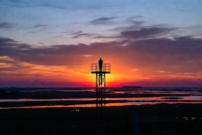 Silhouette man on tower at sunset