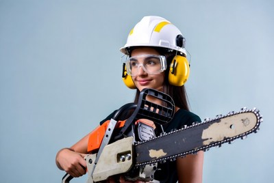 Woman holding chainsaw with helmet