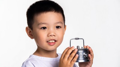 Asian boy holding ornate metal box