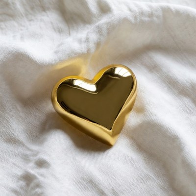 Shiny gold heart on white fabric
