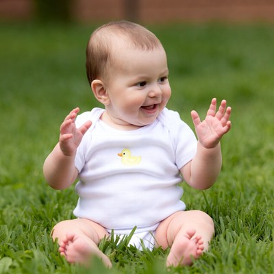 Baby girl clapping on grass
