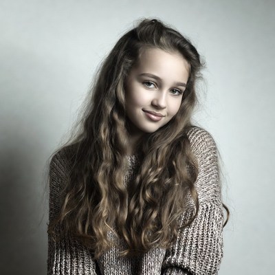 Teen girl with long wavy hair smiling
