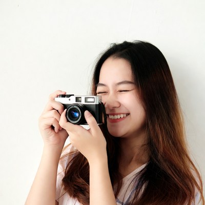 Asian woman holding vintage camera