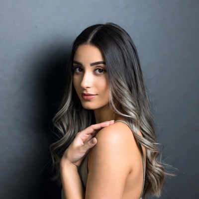 Woman with balayage hair on gray background