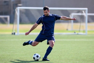 Soccer player kicking ball at goal