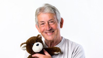 Elderly man holding teddy bear