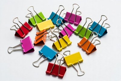 Colorful binder clips on white background