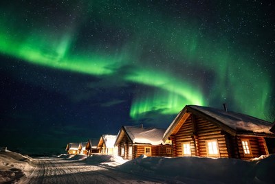 Northern Lights over Snowy Wooden Cabins
