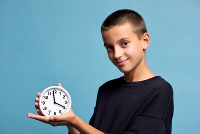 Boy holding white clock