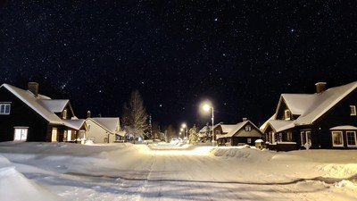 Snowy village street under starry night sky