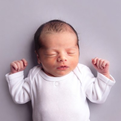 Newborn baby sleeping on gray background