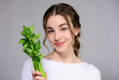 Young woman holding celery