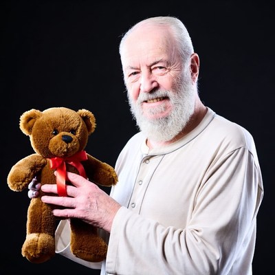 Elderly man holding teddy bear