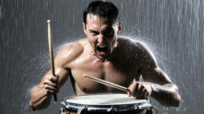Shirtless man drumming in water