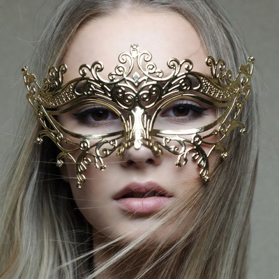 Woman wearing ornate gold masquerade mask