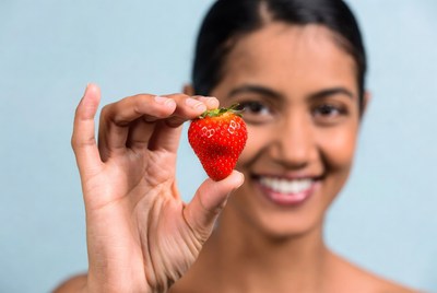 Woman holding fresh strawberry