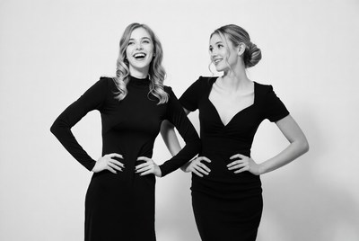 Two smiling women in black dresses