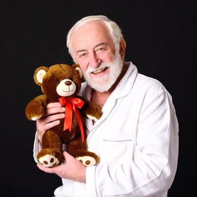 Elderly man holding teddy bear