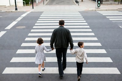 Father walking with children on crosswalk