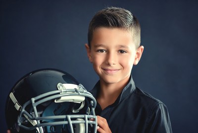 Boy holding football helmet