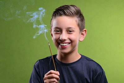 Boy holding lit incense stick