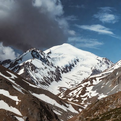 Snowy volcano erupting in mountains