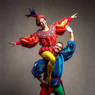 Woman riding man's shoulders in harlequin costumes