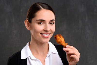 Woman holding chicken wing
