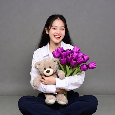 Asian girl holding teddy bear and tulips