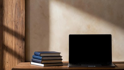 Laptop and stacked books on table