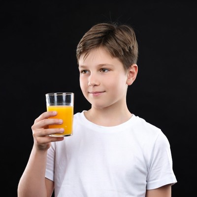 Boy holding glass of orange juice