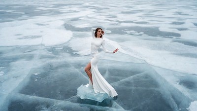 Woman in white dress on frozen lake