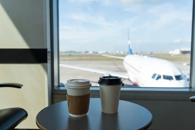 Coffee cups by airport window plane