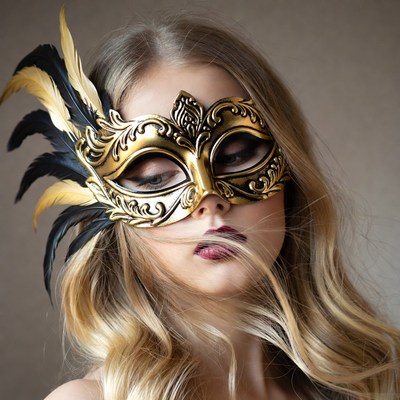 Woman wearing gold feather masquerade mask