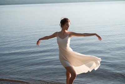 Woman dancing by lake shore