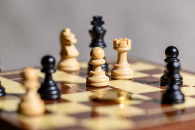 Chess board with pieces and gold coin