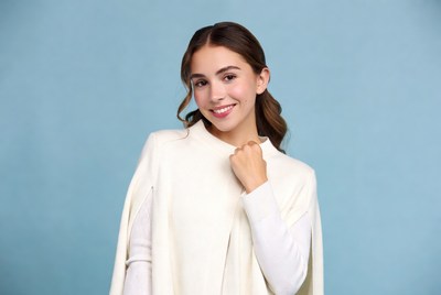 Smiling woman in white cape blue background