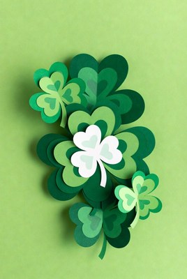 Paper cutout shamrocks on green background