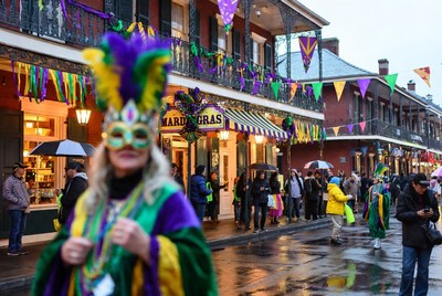 Woman in Mardi Gras costume on rainy street