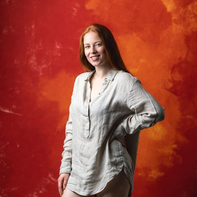 Redhead woman smiling against red background