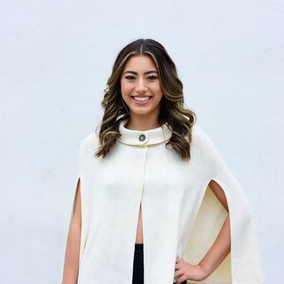 Smiling woman in white cape sweater