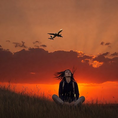Woman watching airplane sunset