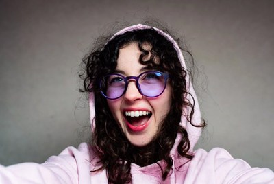 Smiling woman in pink hoodie with glasses