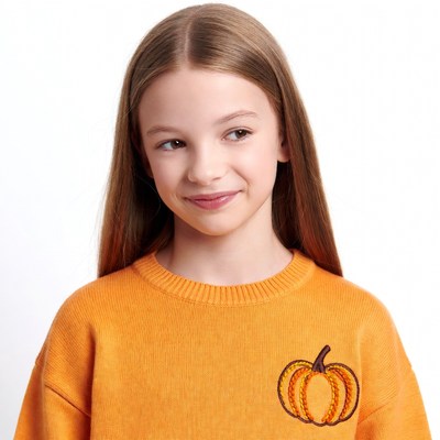 Girl in pumpkin sweater smiling
